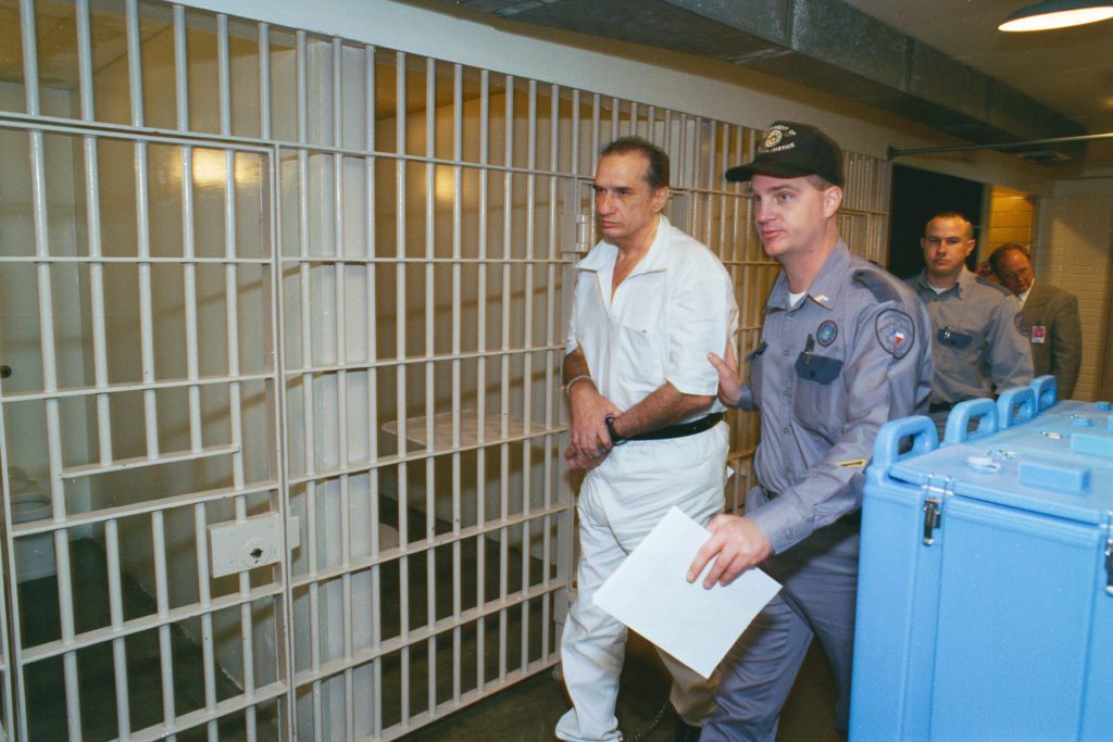 Serial Killer Kenneth Allen McDuff being escorted to a holding cell in the Texas Death Chamber. McDuff, was believed to be the only condemned inmate in the nation ever paroled and then returned to death row for two more murders.  He was sentenced to die in the electric chair in 1966 for killing Robert Brand, one of three teenagers he was charged with randomly killing.  But McDuff was later paroled after the death penalty was overturned.  He was sentenced in two different cases to die by lethal injection for the murders of Melissa Northrup and Colleen Reed.  McDuff was executed shortly after this photograph was taking on November 17, 1998. 